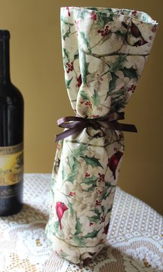 a wine bottle wrapped in fabric and tied with ribbon