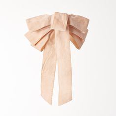 a pink bow is hanging on a white wall in front of a plain, light colored background