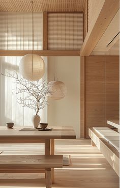 an empty room with wooden floors and white vases on top of the table in front of a window