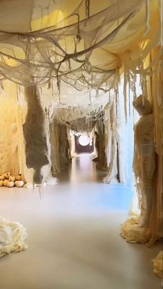 an art installation is shown in the middle of a room with white drapes hanging from it's ceiling