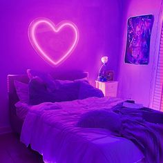 a bed in a room with a heart on the wall above it and purple lighting