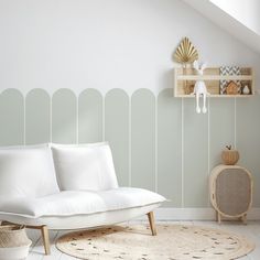 a white couch sitting on top of a rug in a living room next to a wooden shelf