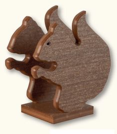 a wooden sculpture of a squirrel holding its tail