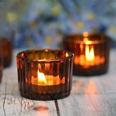 three lit candles sitting on top of a wooden table