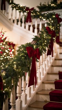 christmas garland on the banisters and stairs with red bows, lights and greenery