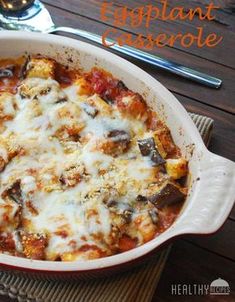 an eggplant casserole in a white dish on a wooden table