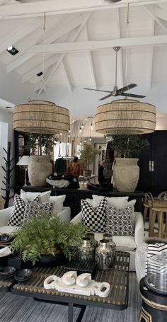 a living room filled with furniture and lots of lamps hanging from the ceiling above it