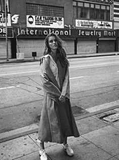 black and white photograph of woman standing on sidewalk