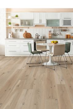 an image of a kitchen setting with wood flooring and white cabinets in the background