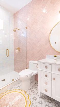 a bathroom with pink and white tiles on the floor, shower, toilet and sink