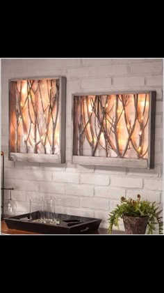 two metal wall art pieces hanging on a brick wall