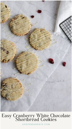 easy cranberry white chocolate shortbread cookies on a sheet of parchment paper with cherries