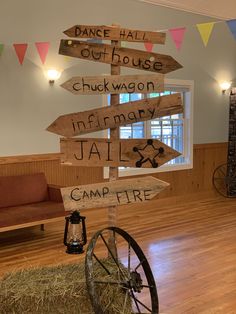 there are many wooden signs on display in the room that says, dance hall out house chuck wagon information jail camp fire