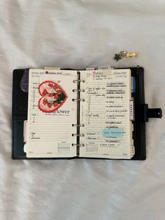 an open planner book sitting on top of a bed