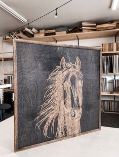 a drawing of a horse on a blackboard in a room with bookshelves