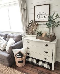 a living room with a gray couch and white dresser