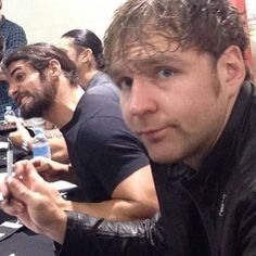 a group of men sitting at a table with cell phones