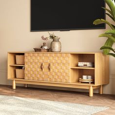 a tv stand with baskets and vases on it