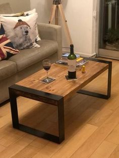 a living room with a couch, coffee table and wine bottle on the floor in front of it