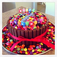 a chocolate birthday cake decorated with candies and candles