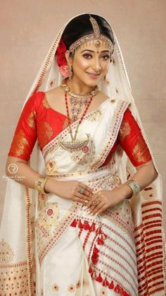 a woman wearing a white and red bridal outfit