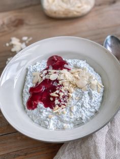 a white bowl filled with oatmeal and toppings on top of a wooden table