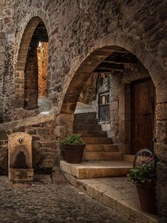 an old stone building with arched doorways and steps