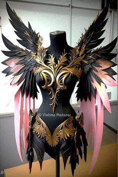 a black mannequin with gold and pink wings