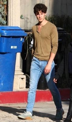 a young man is walking down the street