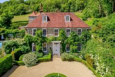 an aerial view of a large house surrounded by greenery