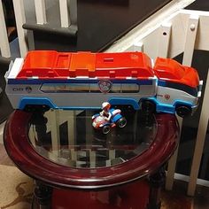 a toy truck is sitting on top of a table next to a stair case and railing