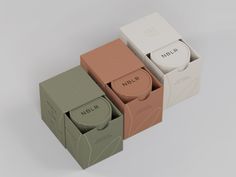 three boxes with different types of soaps in them on a white surface, one is empty and the other has no lid