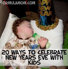 a baby laying on top of a white pillow next to a birthday cake and bottle