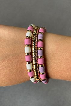 Embrace a chic and vibrant style with this exquisite multi-strand bracelet set. Featuring a delightful mix of pink, purple, and white beads, accented with polished gold-tone spacers, this bracelet adds a pop of color and sophistication to any outfit. The smooth, round beads are paired with flat, disc-shaped beads, creating a dynamic and playful texture. Perfect for layering or wearing alone, this bracelet is an ideal accessory for both casual and formal occasions. Cheap Pink Polymer Clay Bracelets, Pink Beaded Bracelets For Spring, Cheap Pink Polymer Clay Beaded Bracelet, Pink Multi-strand Bracelets With Colorful Beads, Pink Multi-strand Colorful Beaded Bracelets, Pink Multi-strand Colorful Beaded Bracelet, Adjustable Pink Multi-strand Beaded Bracelets, Pink Adjustable Multi-strand Beaded Bracelets, Pink Multi-strand Bracelets As Gift