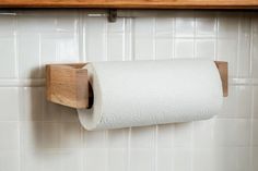 a roll of toilet paper hanging from a wooden holder