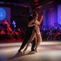 two people dancing on a dance floor in front of an audience