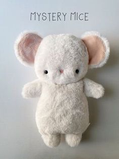 a white stuffed animal with the words mystery mice on it's face and ears