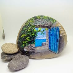 there is a rock with a painting on it and two rocks next to it that have been painted