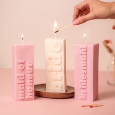 a person lighting candles with the word love spelled out in pink letters on top of them