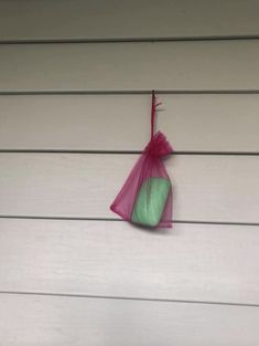 a pink and green bag hanging on the side of a house