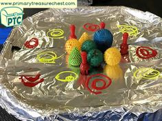 an aluminum foil covered tray with plastic toys on it and the words happy learners written in red