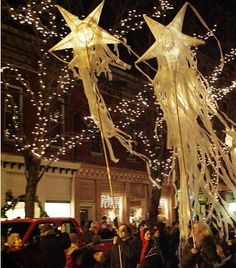 people walking down the street in front of christmas lights