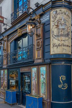 an old building with blue and gold paint on the outside, along side a street