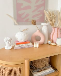 a wooden table topped with books and vases