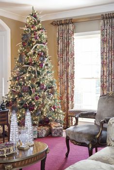 a living room with a christmas tree in the corner and other decorations on the table