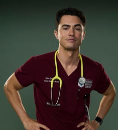 a man with a stethoscope on his neck standing in front of a green background