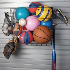 a metal rack with various sports balls and baseballs on it, next to a garage door