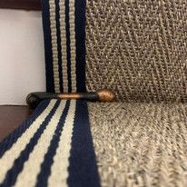 a black and white striped chair with a wooden handle on the armrests next to a wall