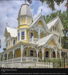 a yellow and blue house with a white picket fence