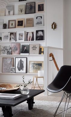 a living room filled with furniture and lots of pictures on the wall above it's coffee table